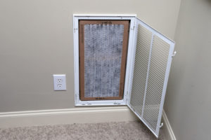 closeup of a dirty air filter in a vent in a houston home that needs to be replaced