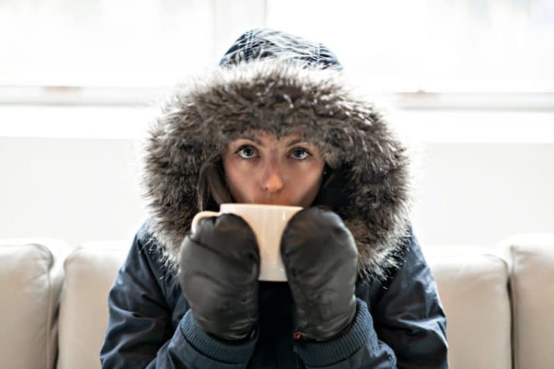 woman sitting in cold home