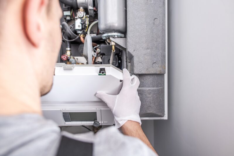 man repairing furnace in a home