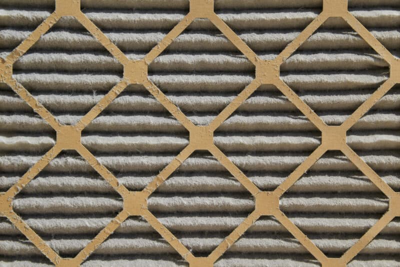 closeup of a dirty air filter covered in dust