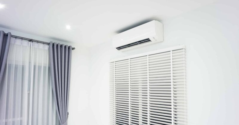 white ductless ac unit installed in home above a window.